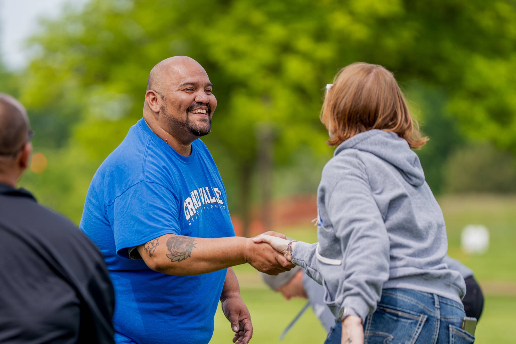 man reaching out to shake woman's hand politely and joyfully